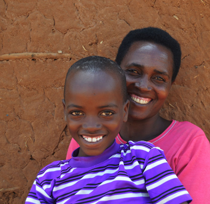 Elisa smiling with his mother in their home in the Uganda refugee camp