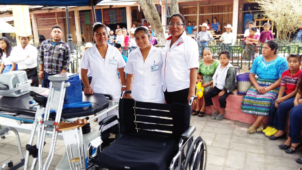 Health workers smiling behind the equipment donated to the health services of Uspantán, Guatemala.