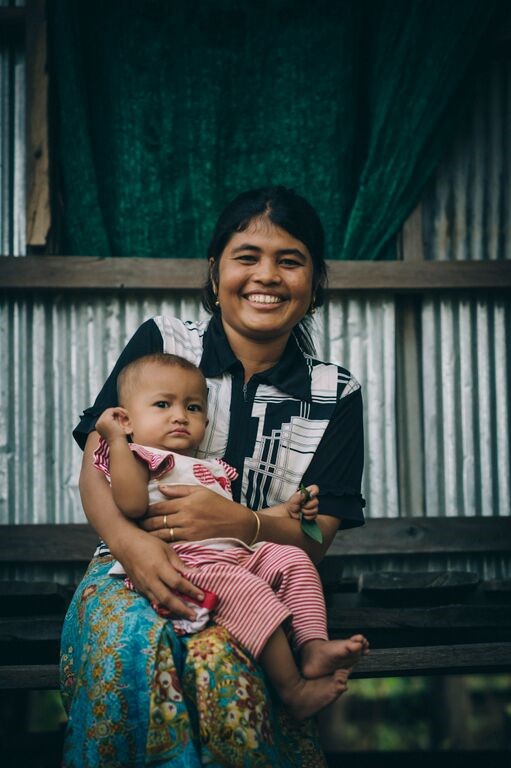 Jocelyne, a resident in Haiti, smiling with her baby that was at risk from malnutrition