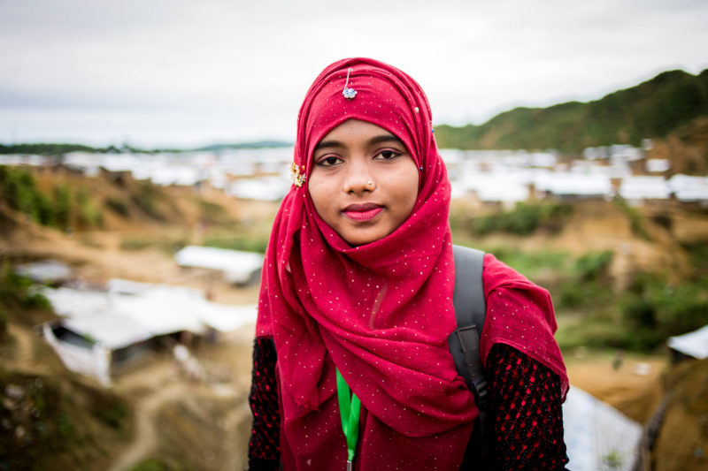 Yasmin, a community health workers in Bangladesh, posing in front of the refugee camps
