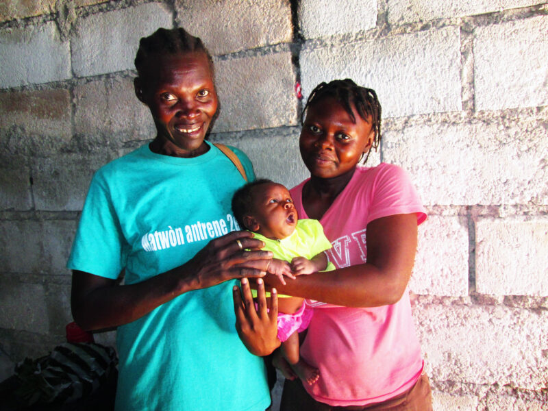 Jaqueline and her daughter Altinise, hold her baby after an almost fatal birth