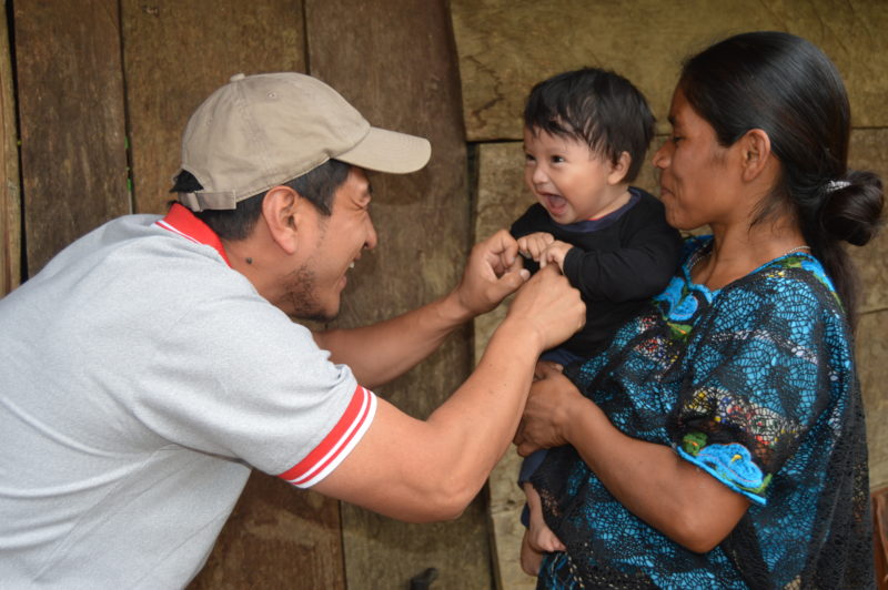 A Medical Teams' staff member plays with Cecilia's baby