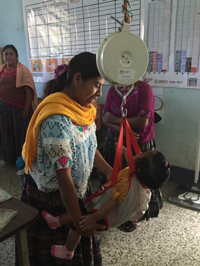 A baby being weighed at a growth monitoring session