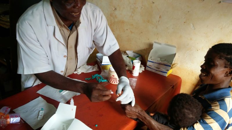 A health worker tests a child for malaria with a Malaria Rapid Diagnostic Test