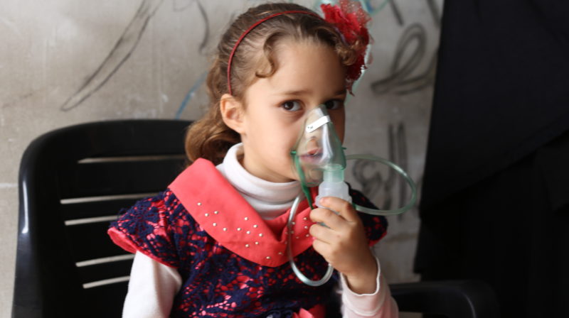 A Syrian girl receives oxygen at a health clinic