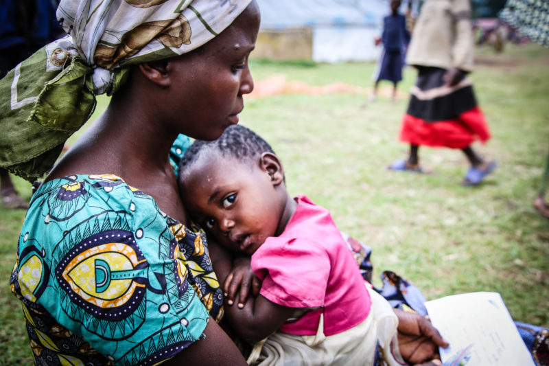 A Uganda refugee mother holding her daughter against her chest