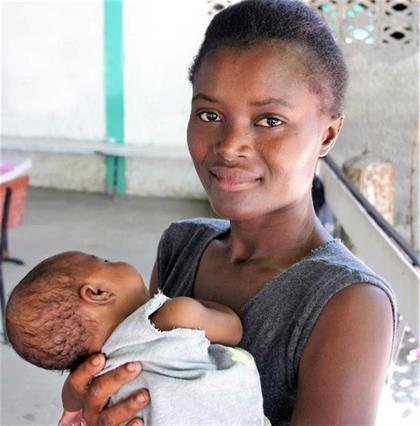 Jocelyne, a resident in rural Haiti, holds Sodberline, her surviving twin who almost succumbed to malnutrition