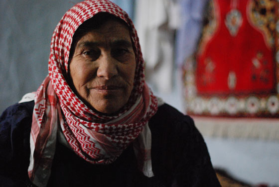 Awash, a Syrian refugee in a Lebanon settlement, smiling in her small tent