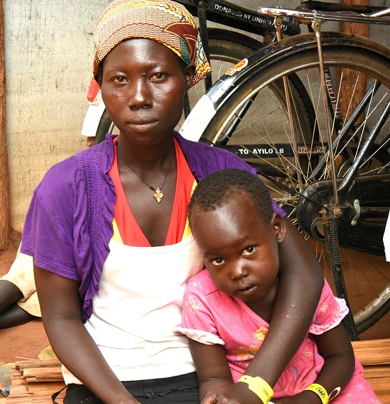 A Uganda refugee mother sitting with her daughter in a refugee settlement