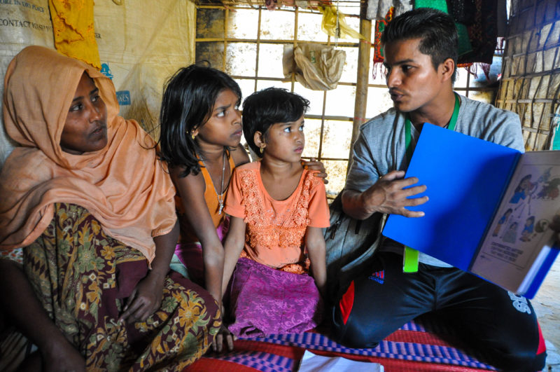 Fatema, a rohingya refugee woman, listens to Redwan, a Medical Teams International community health worker