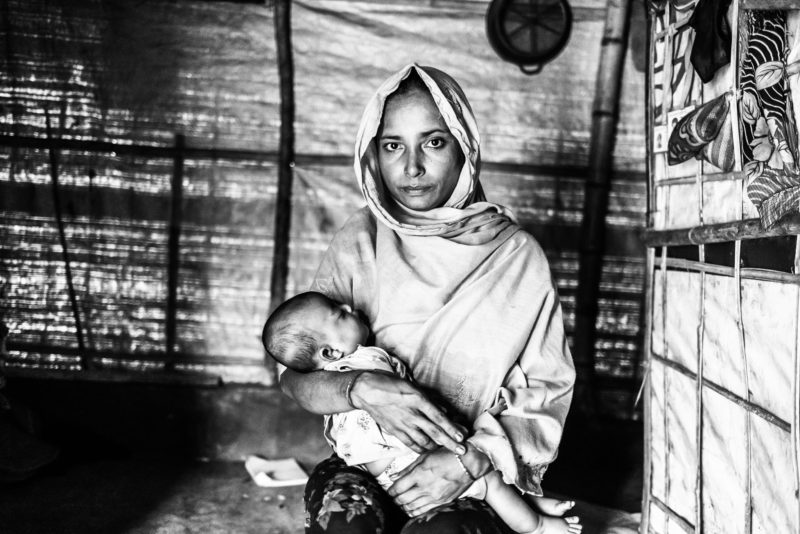 Gul Meher, a Rohingya refugee woman, holding her daughter Shorifa in a Bangladesh refugee camp