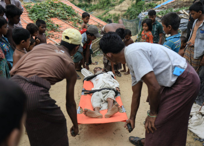 An injured Rohingya refugee man is carried on a stretcher in Bangladesh.