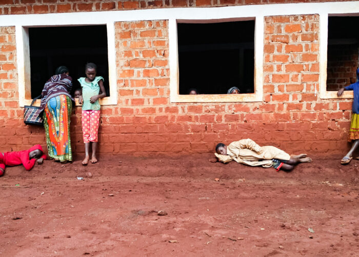 Refugee children leaning against a building in Tanzania.