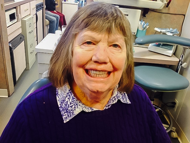 Jillian, a smiling patient who just received dentures in the mobile dental van