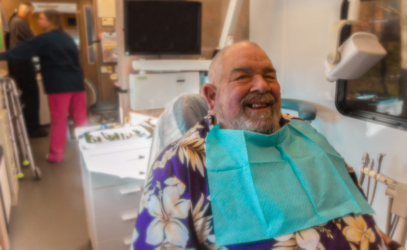 Joe, a smiling patient waiting to get his tooth extracted in the mobile dental clinic