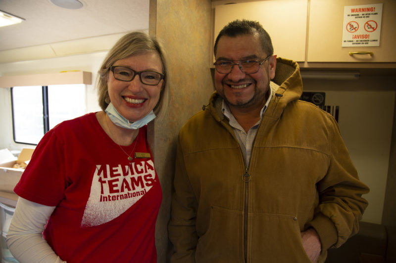 Alberto smiles with volunteer, Kathi, after being treated on board the mobile dental van