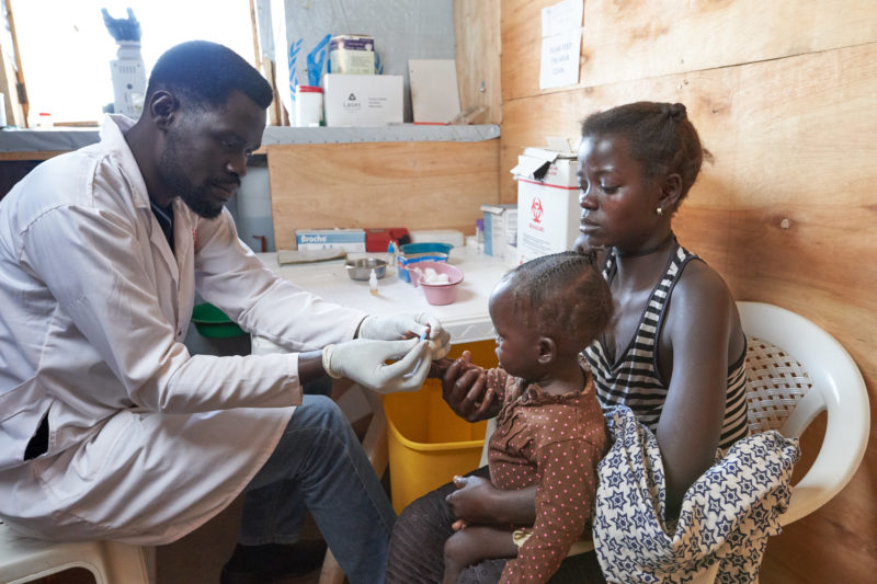 A Medical Teams health worker screens for disease at Kyangwali settlement, Uganda