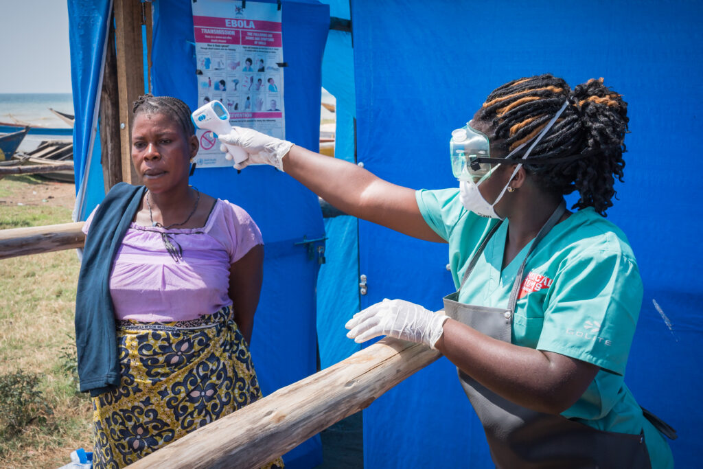 A woman taking the temperature of another woman