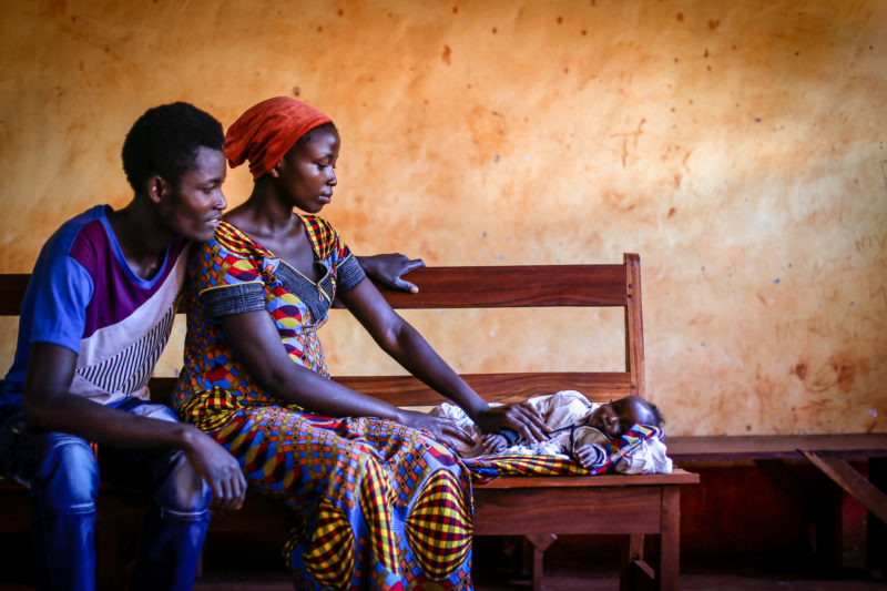 • Fidel and Adella, a young Nyarugusu refugee couple, looking at their newborn child sleep