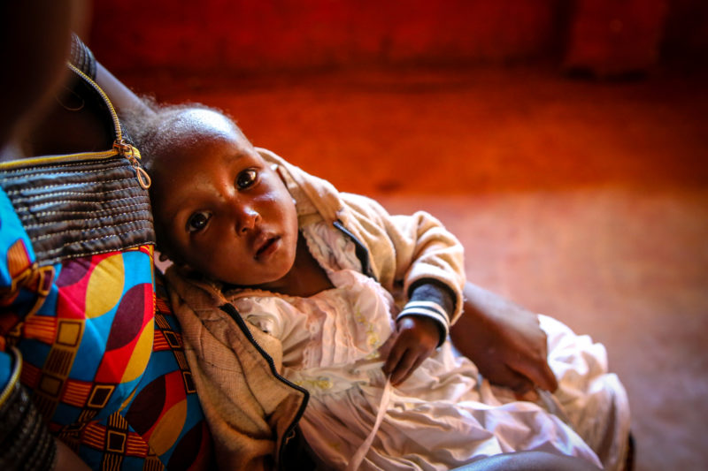 Christina, Fidel and Adella’s baby, looking at her father while being held by her mother