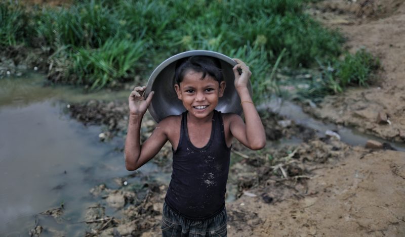 •A Rohingya boy covers himself from the rain in Bangladesh during monsoon season
