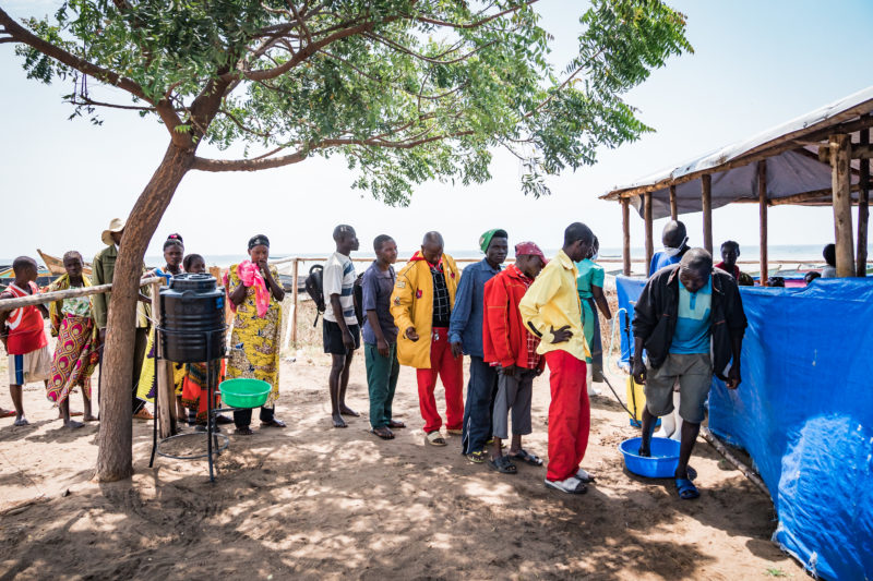 •Congolese refugees standing in line to be screened for Ebola before entering camp