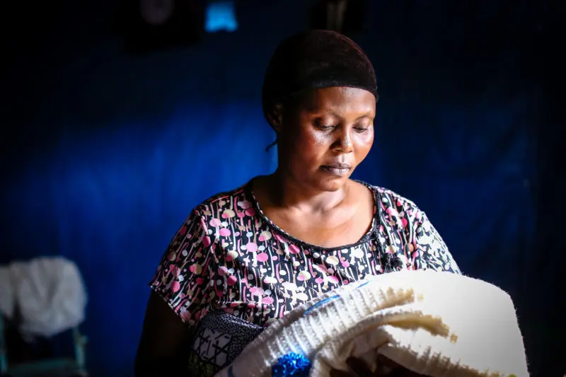 Suzanne, looking down at a blanket that once was her 5-month-olds, who had died from malaria