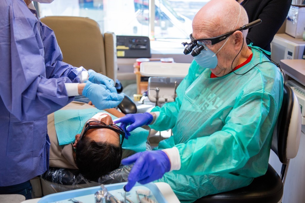 A volunteering dentist in one of the mobile dental vans checking out the teeth of a patient