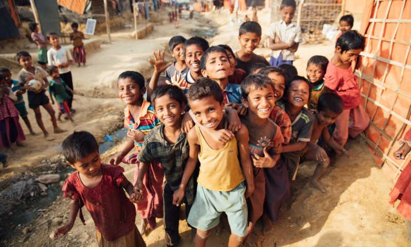 Harun and his friends smiling and enjoying playing soccer