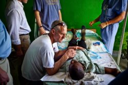 A Medical Teams volunteer checking a survivor of the Haiti earthquake