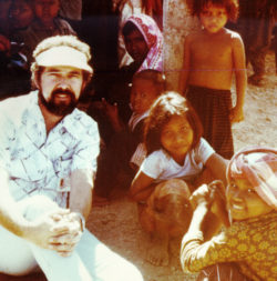 Ron Post, founder of Medical Teams International, sits with Cambodian refugees