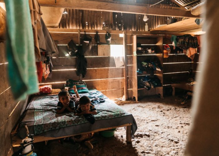 Guatemala boys laying on a bed in their shack