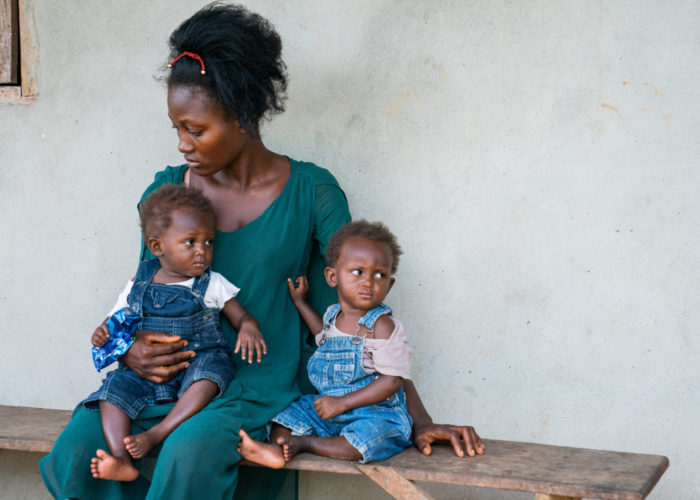 Patient, the mother of twins Terry and Terrika, sitting on a bench in Liberia