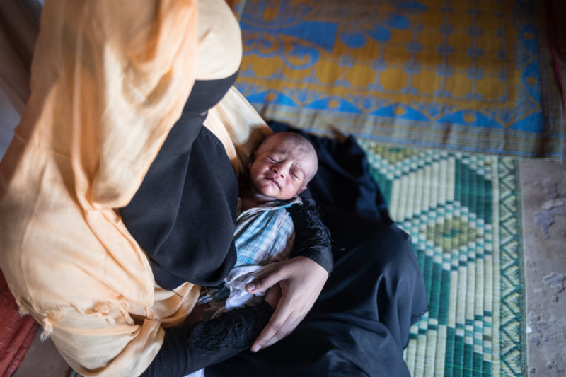 Tasmin Ara, a refugee in Bangladesh, holding her newborn baby girl