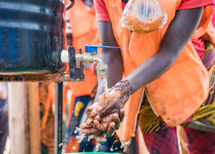 A Ugandan refugee, Kyangwali, washing their hands for Ebola prep