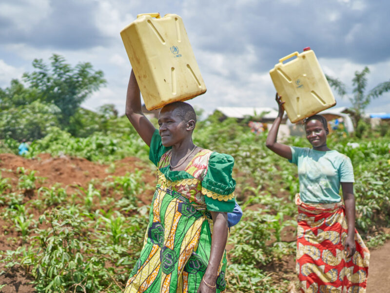 Women Clarice and Beatrice carry jerry cans in Uganda