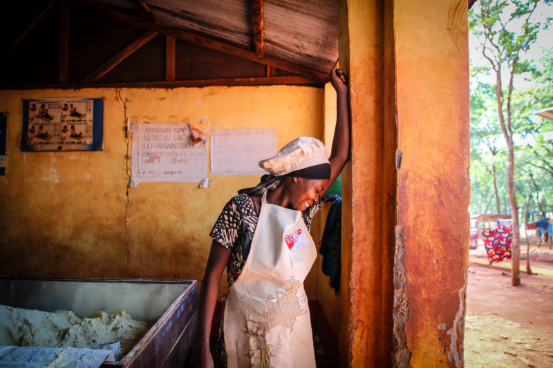 Loveness smiles out her window, after serving malnourished children