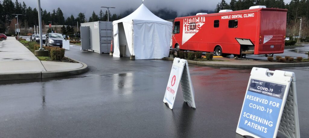 A Medical Teams mobile dental van serves as a COVID-19 testing center in a parking lot