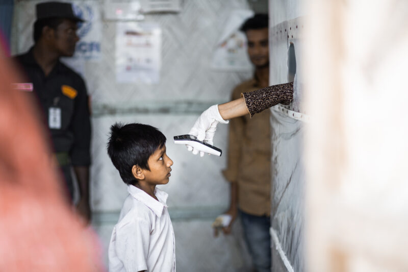 A young refugee boy in Bangladesh is scanned with an infrared thermometer in the Isolation and Treatment Center for COVID-19. 