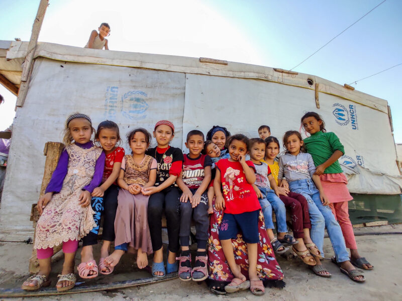 Mazen (center) with his cousins and siblings outside of his home in the refugee settlement in Lebanon. 