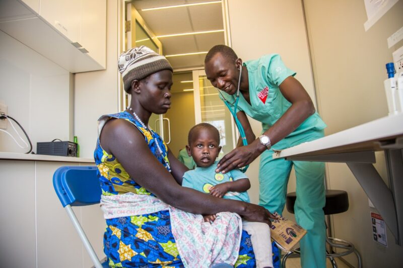 Inside a mobile medical container a doctor examines a child patient, Adjumani, Uganda.