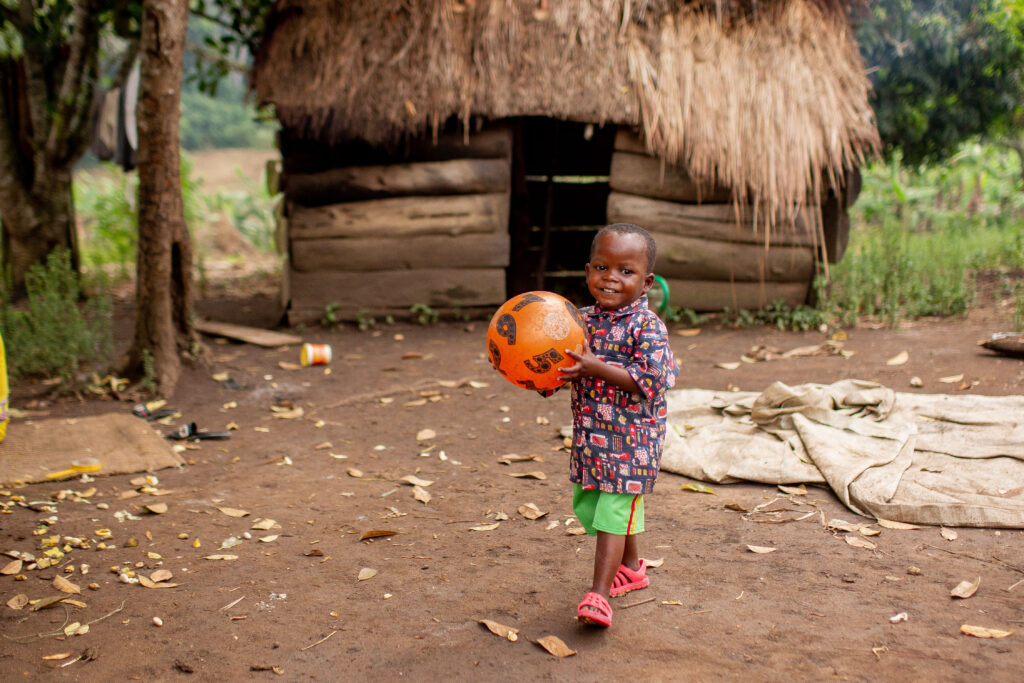 Little boy, smiling, holding orange ball