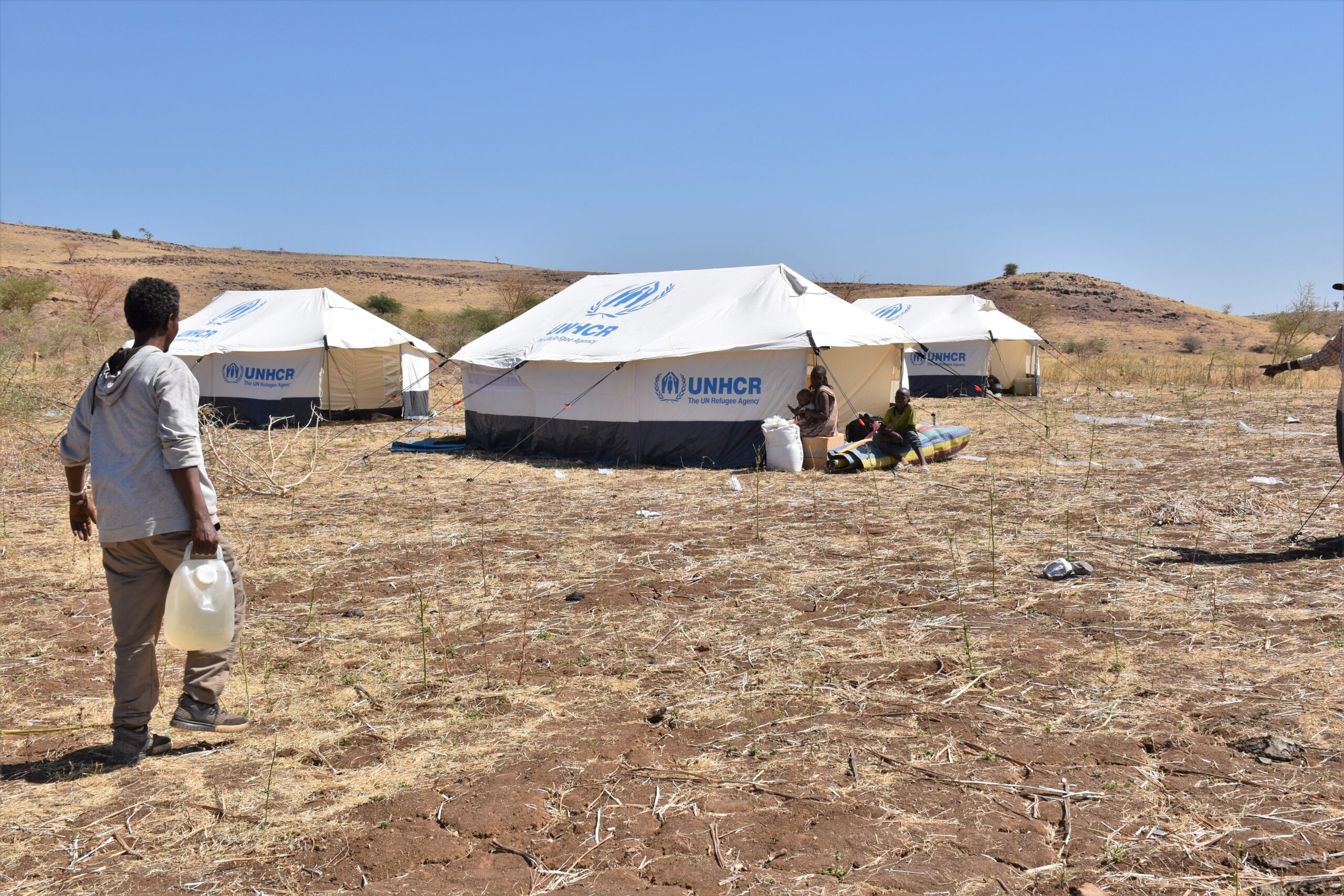 Burhani carries water to his tent in Um Rakouba