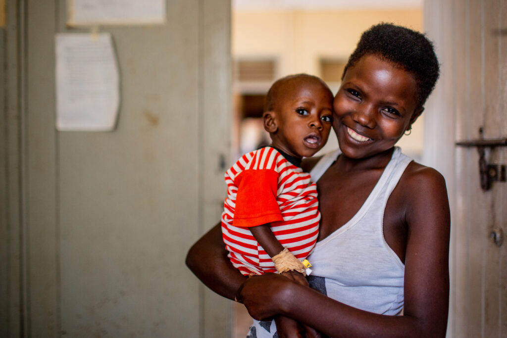 Tusingirwe holds her baby, Namara, in a medical clinic in Uganda.