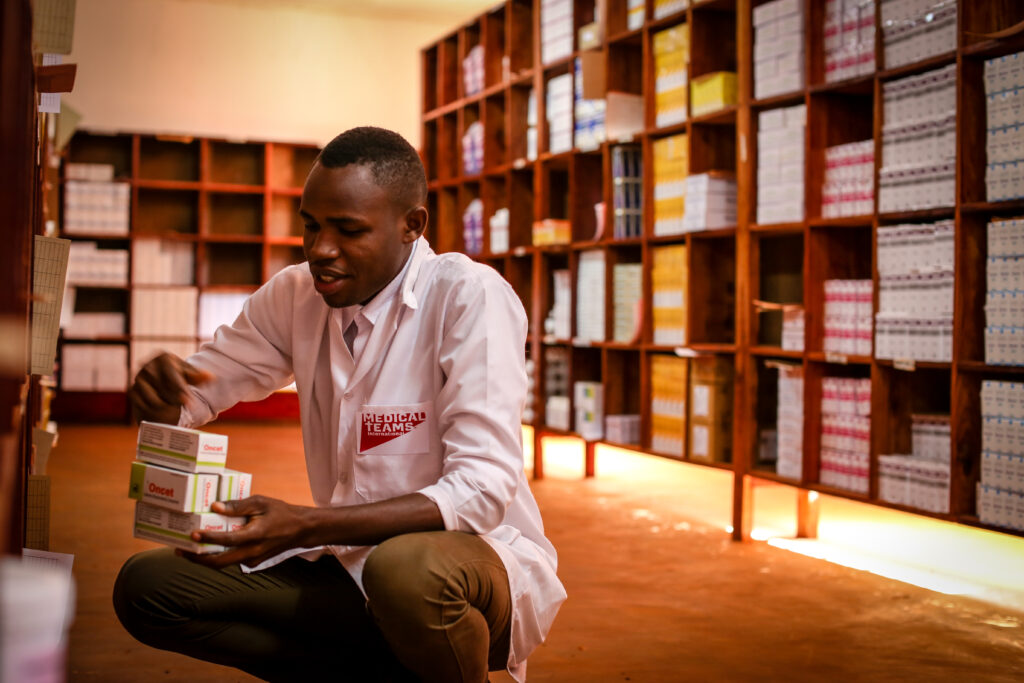 A man organizes medicine in a pharmacy in Tanzania.