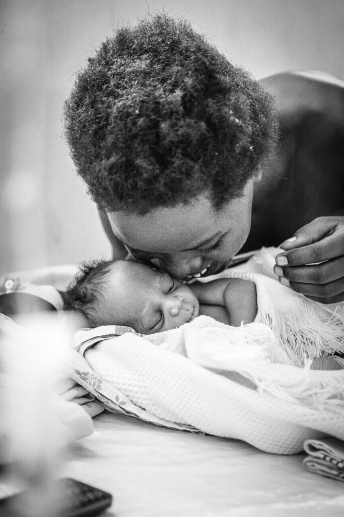 A mother cuddles her newborn baby (photo by Helen Manson)