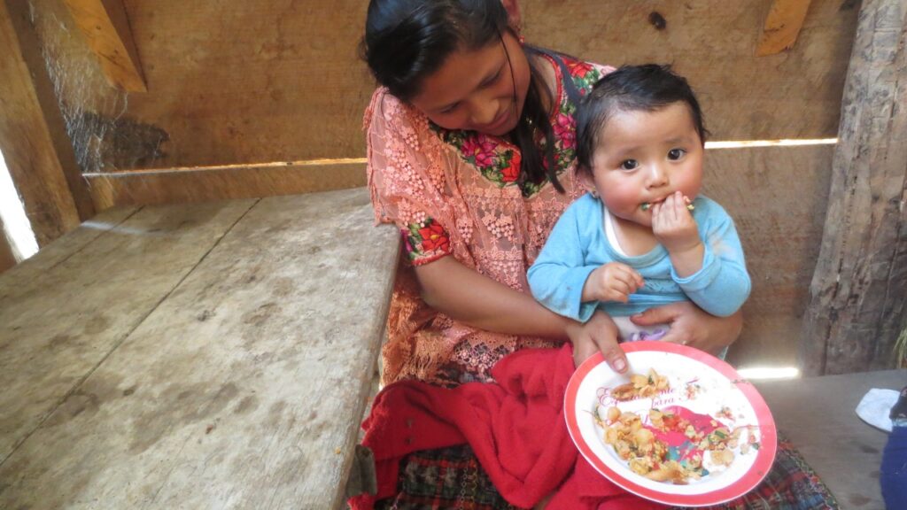 Toddler eating while sitting on her mother's lap