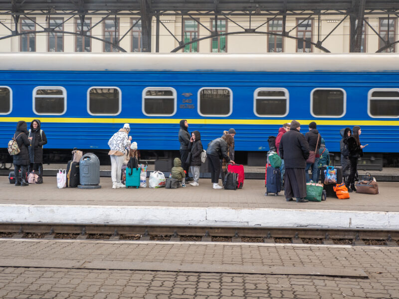 People with bags waiting to board train