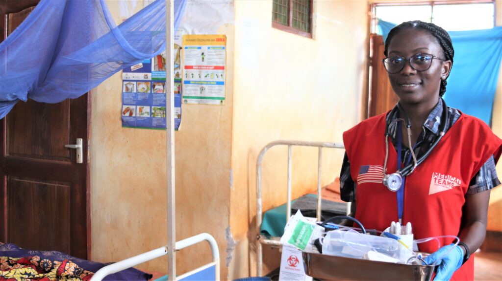 Dr. Eddah carries a box of supplies.