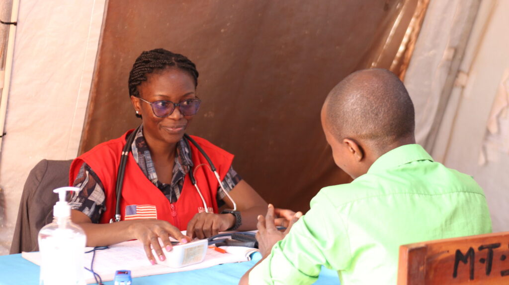 A female doctor helps a patient.